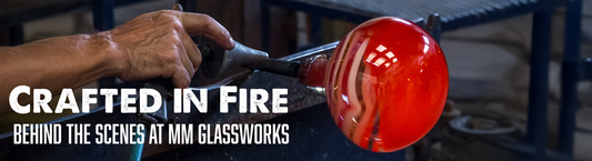 an artisan manually working on hand blown glass